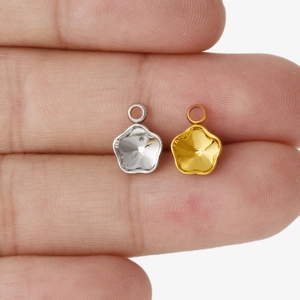 Makroaufnahme von gold- und silbernen fünfblättrigen Blumenanhängern für DIY-Schmuck