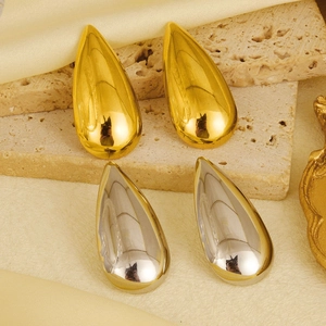 Dettagli degli orecchini a goccia in oro e argento su pietra e tessuto di seta