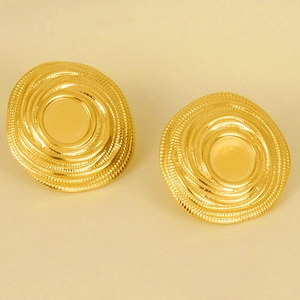 Dettaglio macro di orecchini a vortice dorati con texture a spirale e finitura in oro 18k