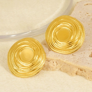 Vista macro di orecchini a lobo in oro 18k con trama a spirale e bordi ondulati