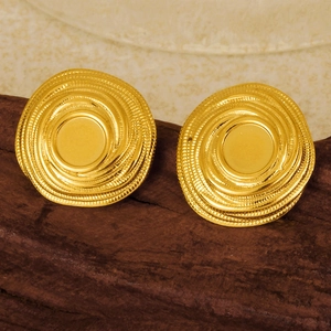 Dettaglio macro di orecchini a lobo a vortice in oro 18k con texture a spirale su legno