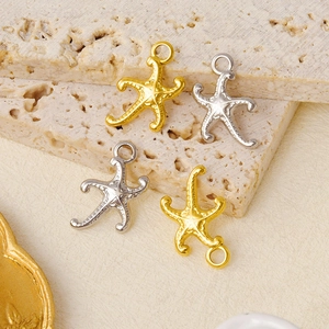 Detailed macro view of starfish jewelry charms in polished gold and silver steel finish