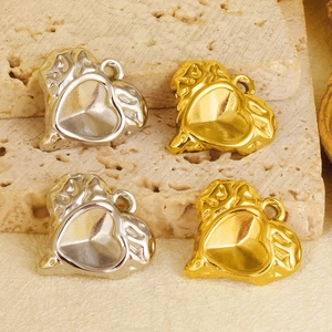Detailed close-up of textured heart pendants in gold and silver finish for DIY jewelry