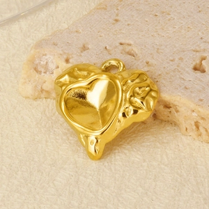 Macro detail of 304 stainless steel heart pendant with hammered texture and 18k gold plating