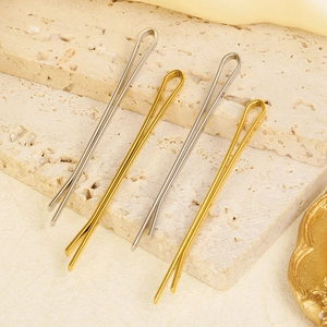 Detaillierte Ansicht minimalistischer goldener und silberner Haarklammern auf Marmor