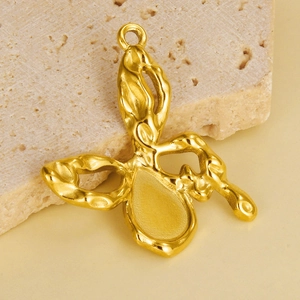 Macro detail of a 304 stainless steel butterfly pendant with golden hammered texture