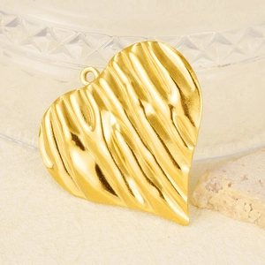 Detail-Makroaufnahme des goldenen Herzanhängers mit gewellter Textur und poliertem Finish