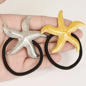 Detailed close-up of 18k gold and silver starfish hair ties with textured metal finish
