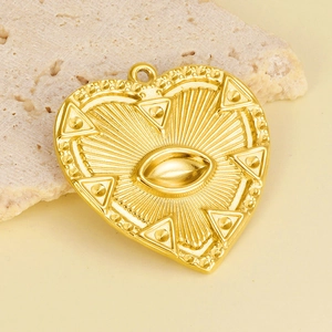 Detailed close-up of a gold heart charm with an evil eye and sunburst pattern on stone