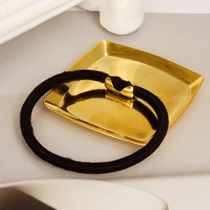 Detail of high-elastic black hair tie with premium polished gold curved metal fastener