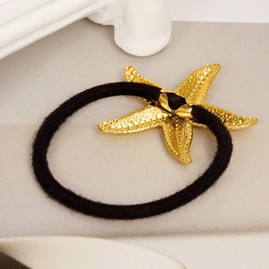 Gros plan d'un pendentif étoile de mer en or 18 carats sur un élastique à cheveux