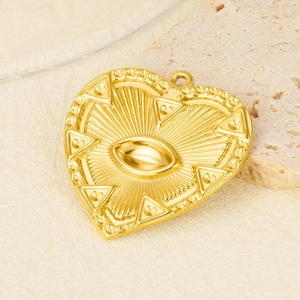 Detailed macro view of heart-shaped gold-plated pendant with sunburst eye motif