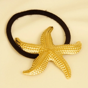 Detail shot of golden 304 stainless steel starfish charm on black elastic hair tie