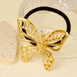 Détail de l'élastique à cheveux papillon doré ajouré sur un fond décoratif élégant et chic