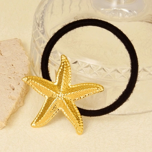 Élastique à cheveux étoile de mer or 18k avec cordon noir sur fond texturé élégant
