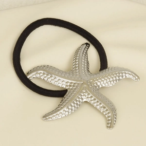 Detail view of the silver starfish charm with textured surface on a black elastic hair tie