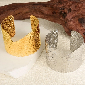 Vue détaillée de larges bracelets joncs en acier inoxydable 304 avec texture martelée