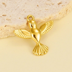 Macro shot of flying bird pendant in gold finish with detailed wing engravings