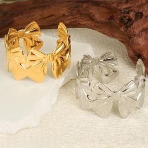 Détail des bracelets joncs nœuds plaqués or 18 carats et argent sur support en pierre
