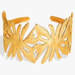 Macro detail of gold plated 304 stainless steel bracelet with hollow plant leaf texture
