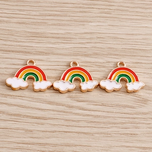 Macro detail of three colorful enamel rainbow and white cloud DIY pendant charms
