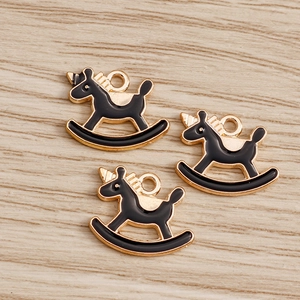 Détails de trois pendentifs licorne cheval à bascule en émail noir et doré chic