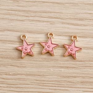 Macro shot of pink enamel star charms with gold trim for handmade DIY jewelry