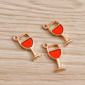 Macro detail of red enamel wine glass charms with gold metal edges for DIY jewelry