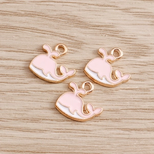 Détail des pendentifs baleine en émail rose et blanc pour la création de bijoux DIY
