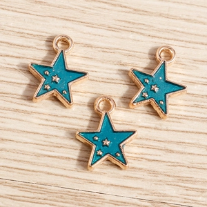 Macro shot of three star-shaped alloy pendants with light blue enamel and golden star dots