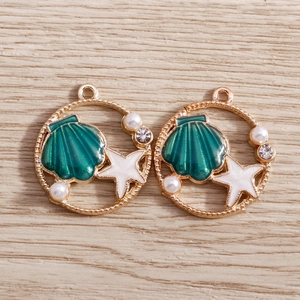 Detail of DIY ocean theme pendant with green enamel shell, stars and pearls on gold plating