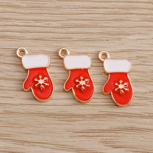 Detalle de colgantes de guantes de Navidad en esmalte rojo con copo dorado para joyería manual