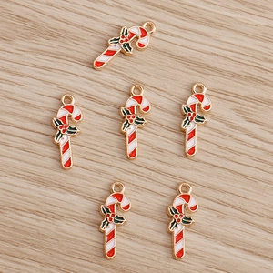 Detailed view of red and white enamel Christmas candy cane charms for DIY crafts