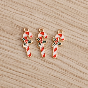 Detail of enamel Christmas candy cane charms with holly leaves for DIY jewelry making