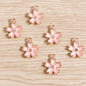Pink enamel cherry blossom pendants with gold alloy plating and central rhinestone accents