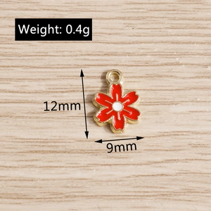 Vue détaillée du pendentif fleur de cerisier en émail rouge avec dimensions 12mm et 9mm
