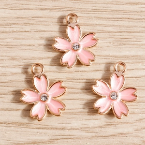 Detailed close-up of pink cherry blossom pendants with rose gold edges and small zircons