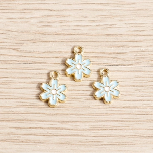 Trois breloques fleurs en émail bleu clair avec base dorée pour création de bijoux