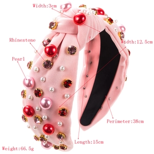Close-up showing the pink knot headband with pearls, rhinestones and fabric texture details