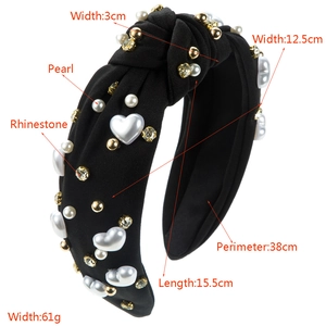 Detailed close-up of a black knotted headband featuring rhinestones and white pearls
