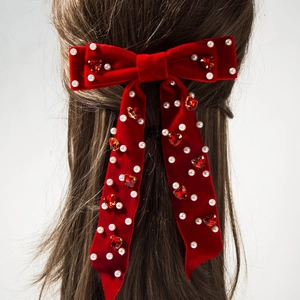 Détail de la pince à cheveux noeud en velours rouge avec perles et strass coeur