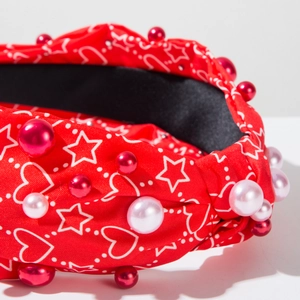 Vue détaillée d'un serre-tête rouge avec motifs cœurs et perles fantaisie colorées