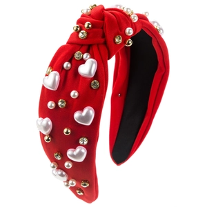 Close-up of red knotted headband with white heart pearls and sparkling rhinestones