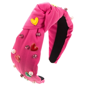 Dettaglio fascia rosa annodata con ciondoli a cuore, strass e perle