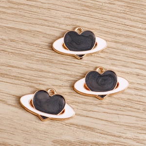 Macro di tre ciondoli a forma di pianeta a cuore con trama marmo nero e bordi dorati