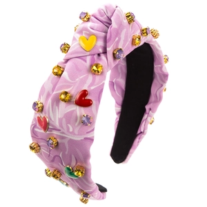 Dettaglio di un cerchietto annodato lavanda con strass colorati e ciondoli a forma di cuore