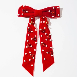 Détail de la pince à cheveux noeud en velours rouge avec perles et gemmes en coeur