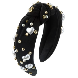 Detail of black knotted headband with white pearls, heart beads, and gold studs