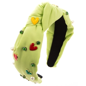 Dettaglio cerchietto annodato verde chiaro con ciondoli a cuore, perle e strass smeraldo