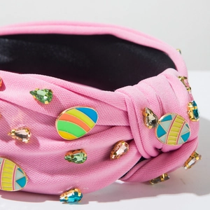Détail d'un bandeau rose avec breloques d'œufs de Pâques colorés et cristaux brillants